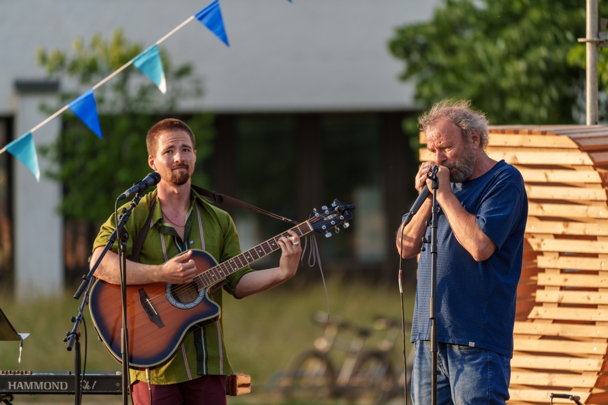 Bernharp und flowoflife live auf der Bühne — Vater an der Mundharmonika, Florian an Gitarre und Mikrofon
